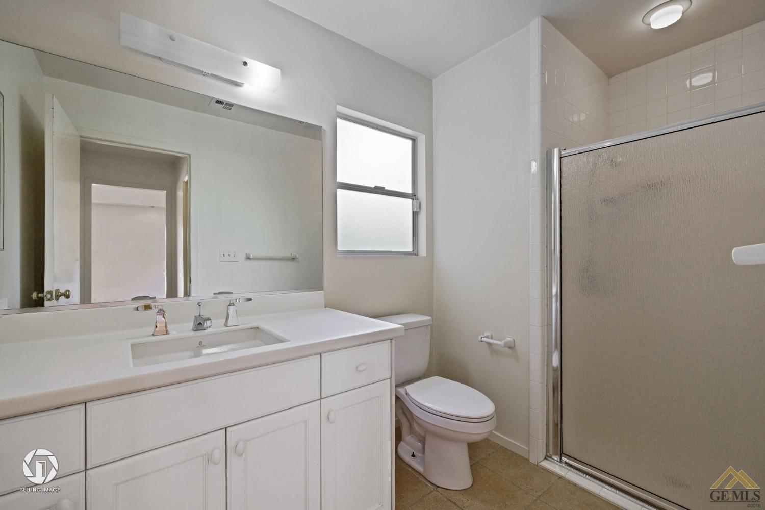 Undisclosed Address Bakersfield, CA 93309 - Photo 38 of 63 a bathroom with a toilet a sink a mirror and a shower