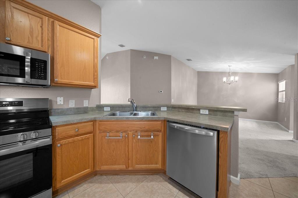 4555 Southwest 52nd Circle, Unit 106 Ocala, FL 34474 - Photo 11 of 100 a kitchen with a sink stove top oven and cabinets