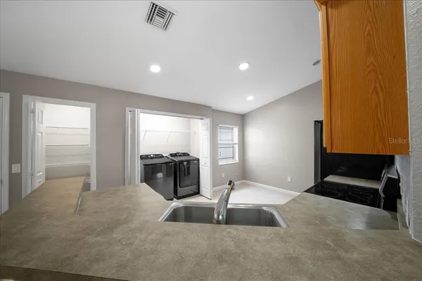 an empty room with windows and ceiling fan