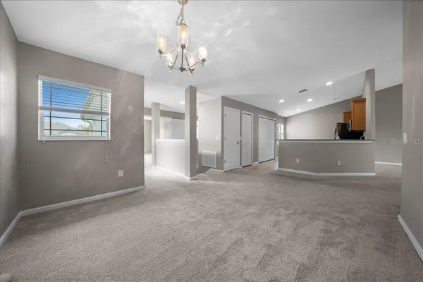 an empty room with a ceiling fan and a window
