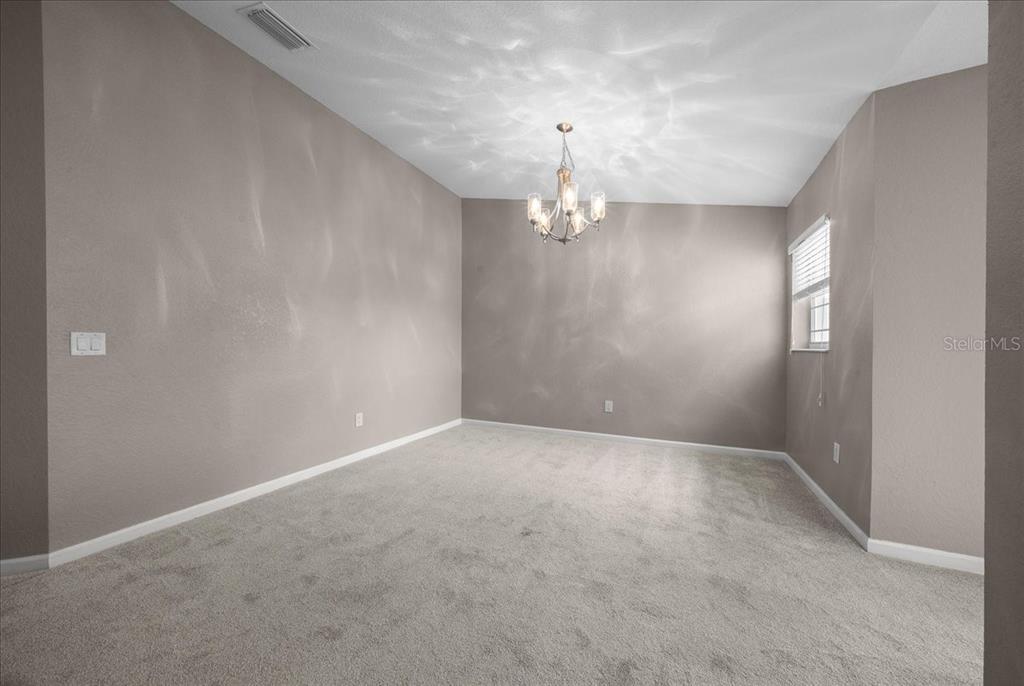 4555 Southwest 52nd Circle, Unit 106 Ocala, FL 34474 - Photo 18 of 100 en empty room with windows and chandelier fan