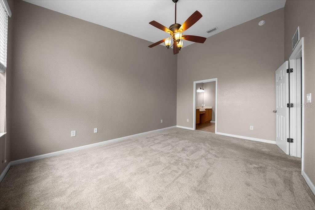 4555 Southwest 52nd Circle, Unit 106 Ocala, FL 34474 - Photo 22 of 100 an empty room with a chandelier fan and a window