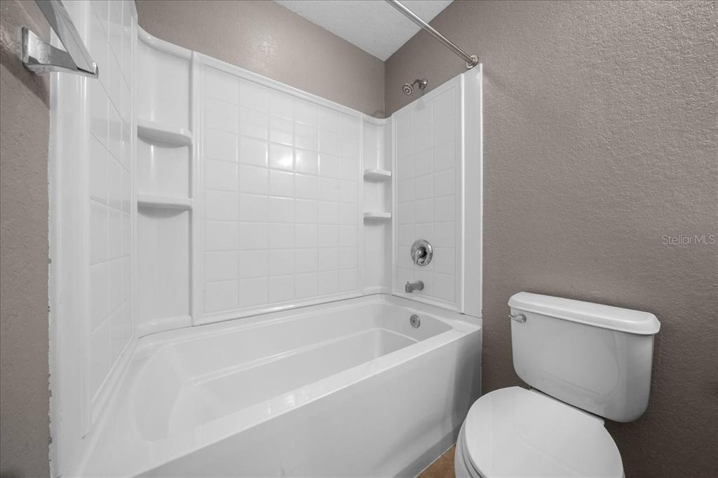 4555 Southwest 52nd Circle, Unit 106 Ocala, FL 34474 - Photo 39 of 100 a white toilet sitting next to a bath tub