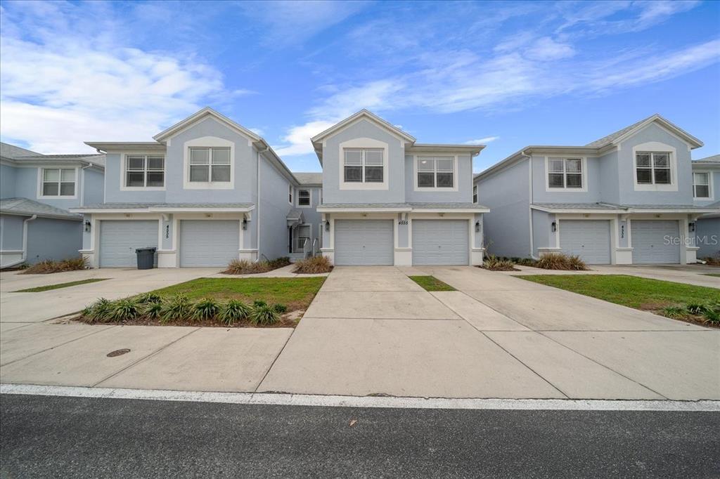 4555 Southwest 52nd Circle, Unit 106 Ocala, FL 34474 - Photo 90 of 100 a front view of a house with a yard and potted plants