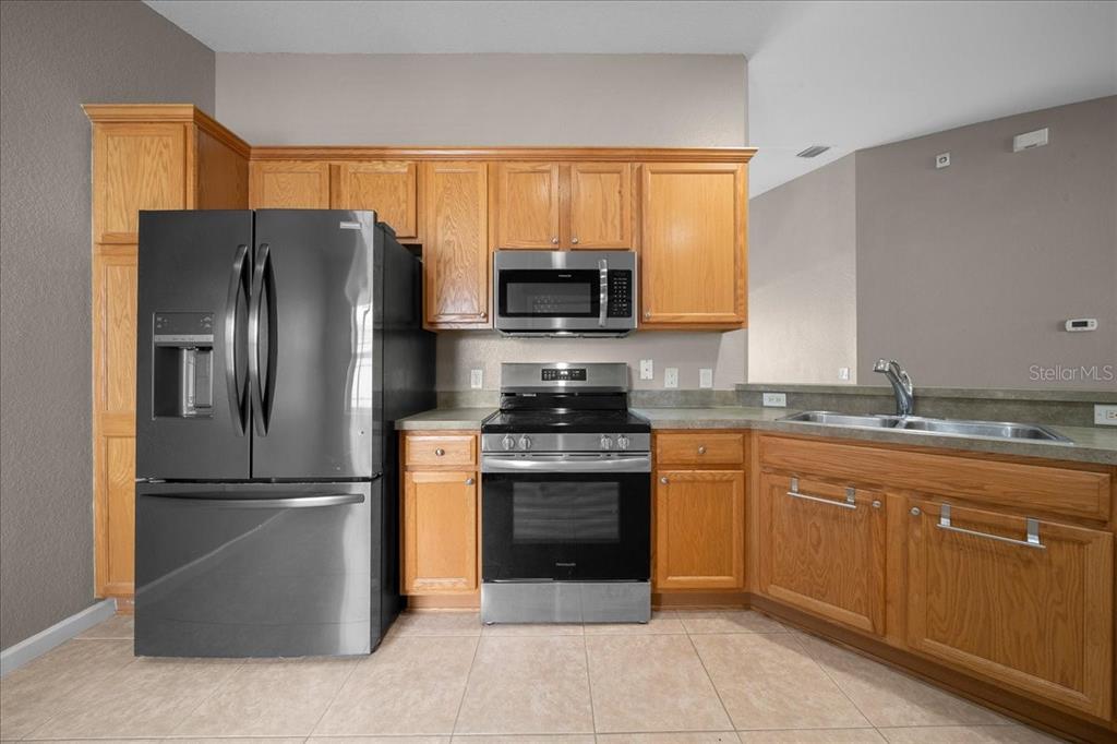 4555 Southwest 52nd Circle, Unit 106 Ocala, FL 34474 - Photo 10 of 100 a kitchen with stainless steel appliances granite countertop a stove a refrigerator and a microwave
