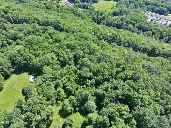 an aerial view of a house with a lush green forest
