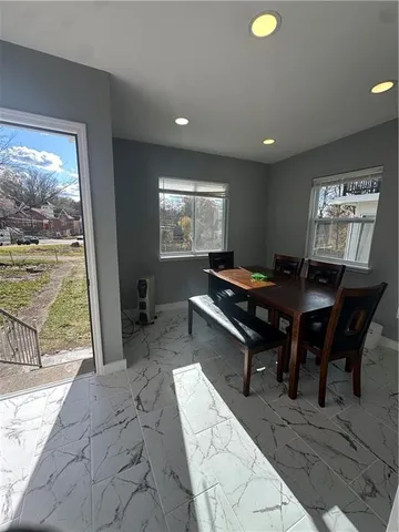 a dining room with furniture and view of kitchen