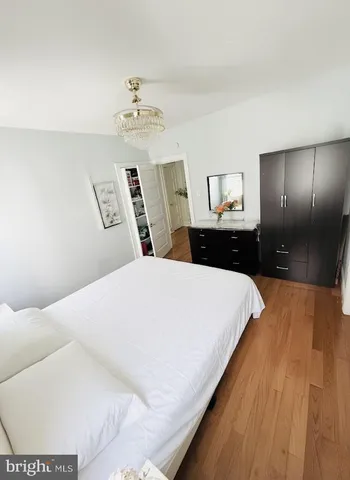 a spacious bedroom with a bed and a chandelier