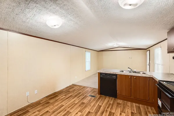 a kitchen with a sink and wooden floor