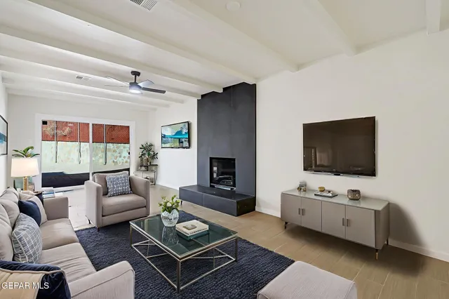 a living room with furniture a flat screen tv and a fireplace