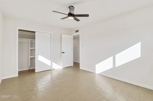 a view of a livingroom with a ceiling fan and wooden floor