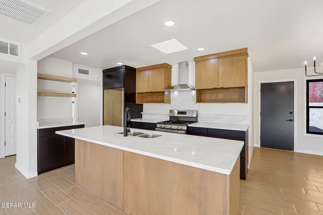 a kitchen with stainless steel appliances a sink stove and refrigerator