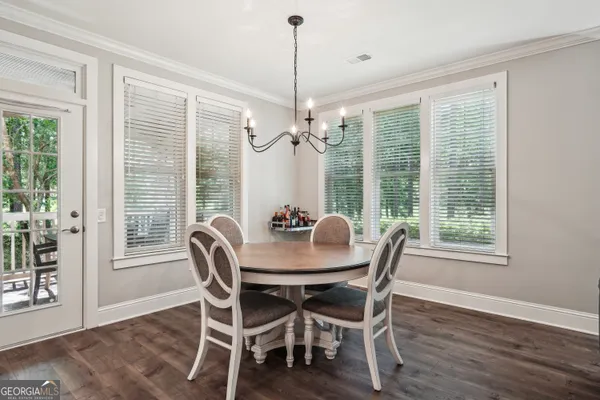 a dining room with furniture a chandelier and wooden floor
