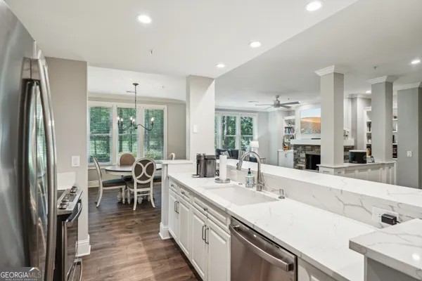 a kitchen with stainless steel appliances a dining table chairs and window
