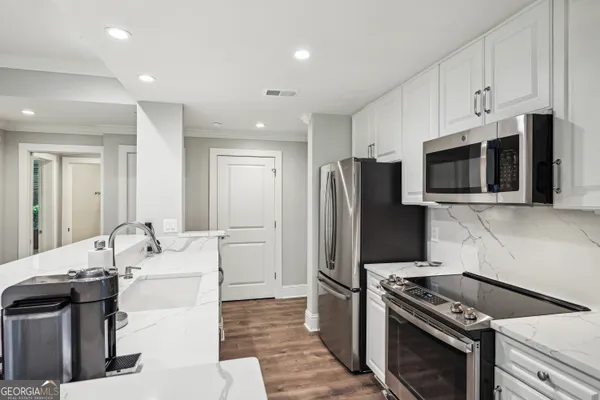 a kitchen with stainless steel appliances a refrigerator a stove top oven and cabinets