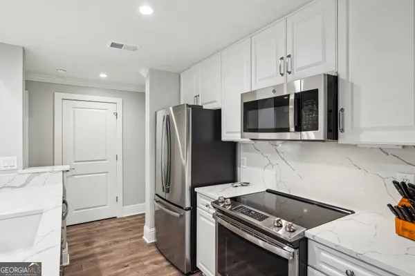 a kitchen with stainless steel appliances kitchen island granite countertop a refrigerator and a stove top oven