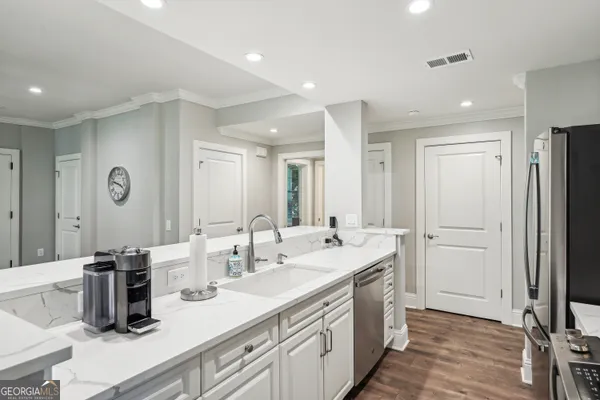 a kitchen with refrigerator a stove and white cabinets