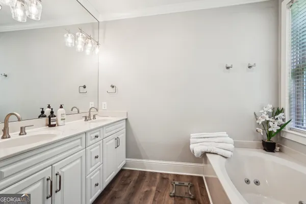 a bathroom with a sink a large mirror and a window