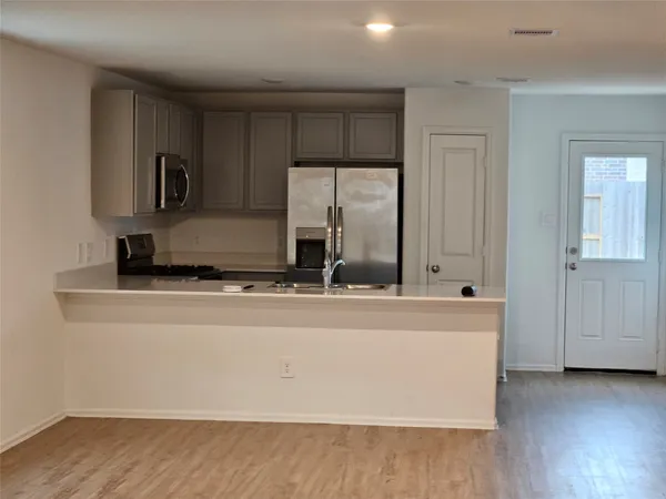 a view of a kitchen with cabinets and wooden floor
