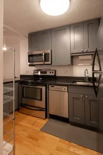 a kitchen with stainless steel appliances granite countertop a stove a sink and a refrigerator