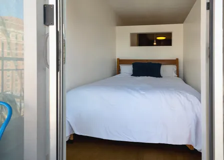 a bed sitting in a bedroom next to a window