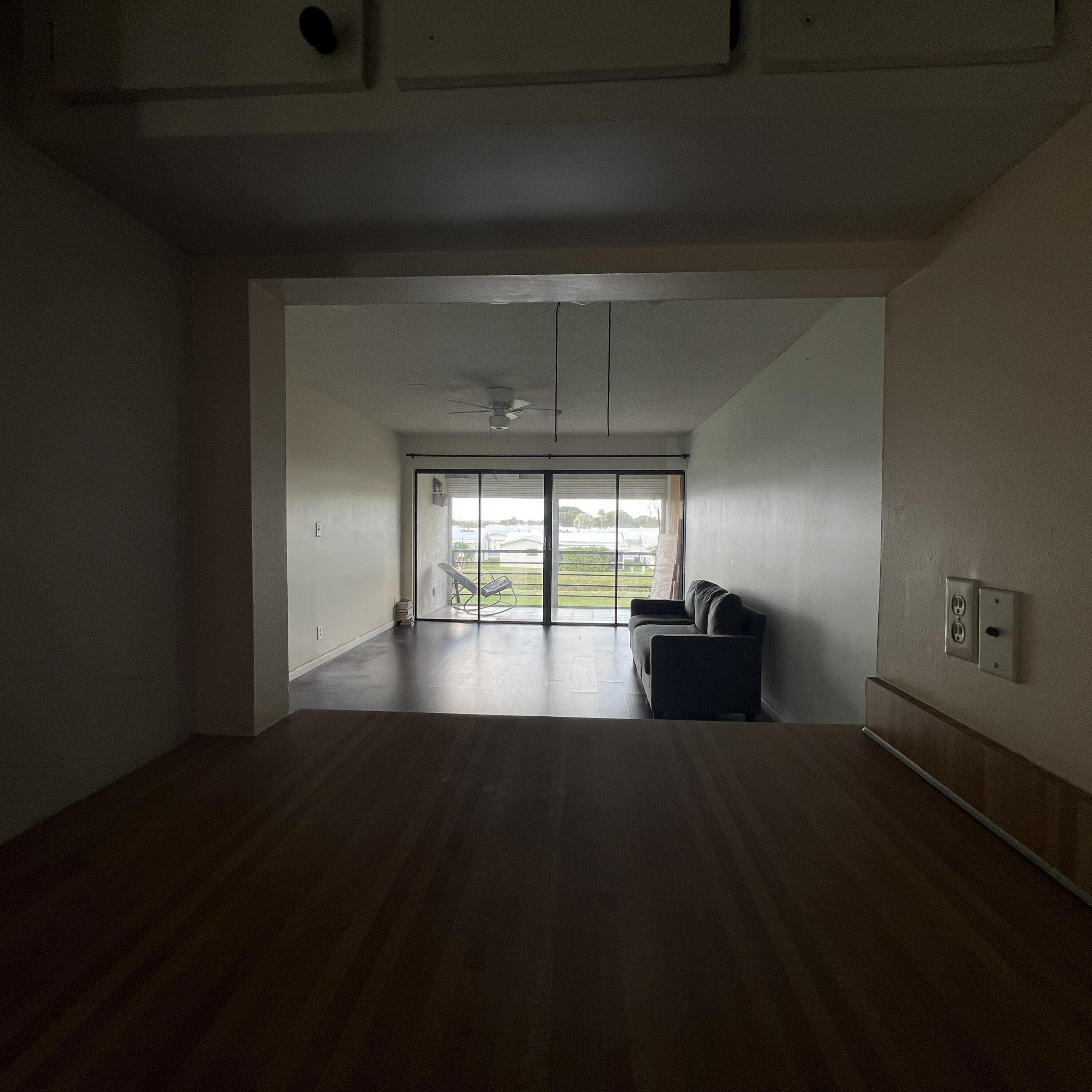 2141 Woolbright Road, Unit L204 Boynton Beach, FL 33426 - Photo 7 of 18 a view of empty room with wooden floor and fan