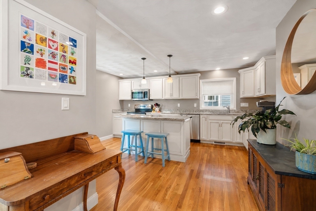 46 MacArthur Road Stoneham, MA 02180 - Photo 21 of 41 a kitchen with a table chairs microwave and cabinets