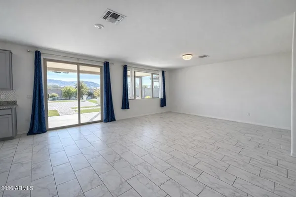 a view of a big room with windows and chandelier fan