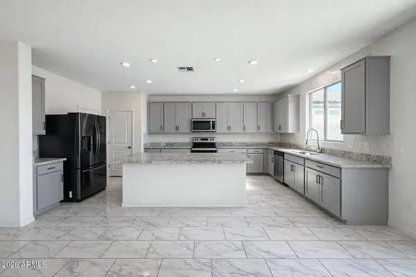 a large kitchen with a large window and stainless steel appliances
