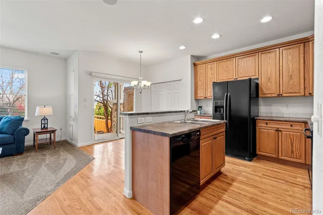 a kitchen with stainless steel appliances granite countertop a sink a stove and a wooden floor