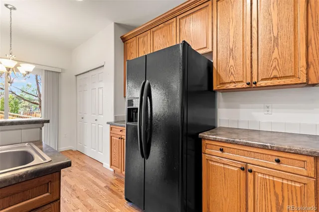 a living room with stainless steel appliances furniture and a kitchen view