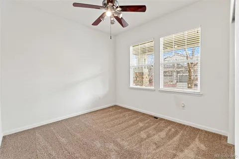 a living room with furniture a window and a ceiling fan