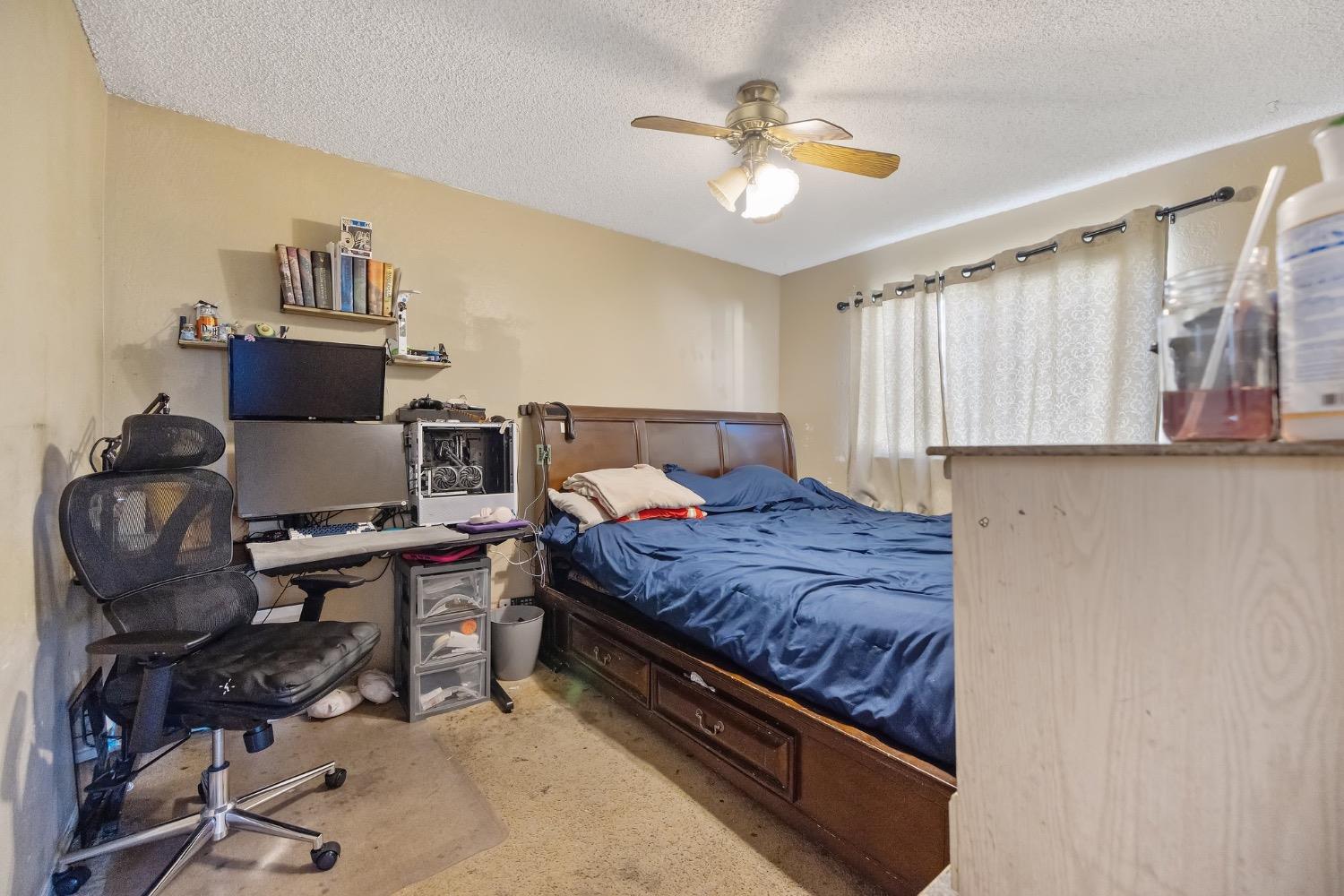 709 Ashlan Way Madera, CA 93638 - Photo 15 of 23 a bedroom with a bed and a chandelier