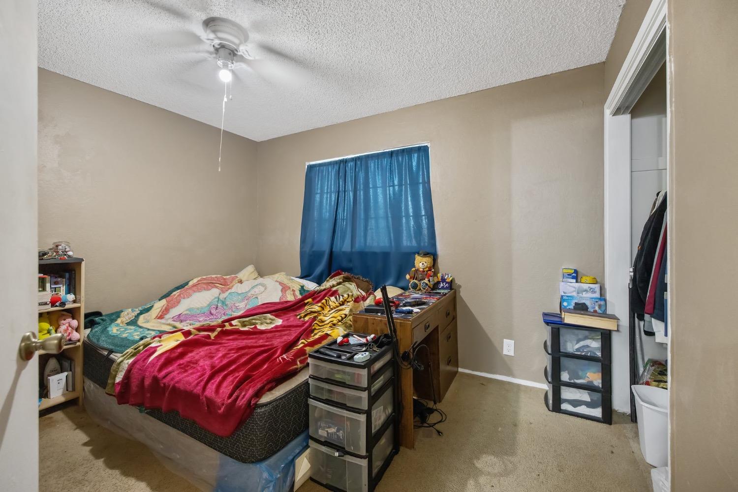 709 Ashlan Way Madera, CA 93638 - Photo 19 of 23 a bedroom with a bed and a chandelier