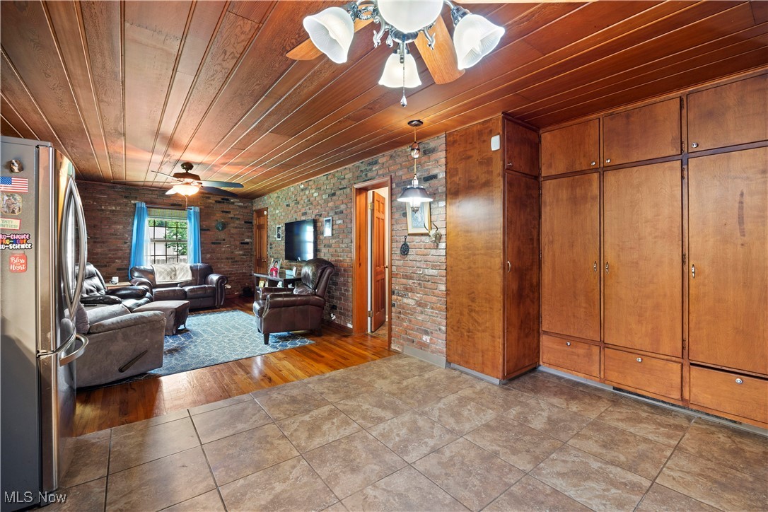 11632 Robson Road Grafton, OH 44044 - Photo 24 of 48 Living room featuring brick wall, wooden ceiling, and ceramic tile floors