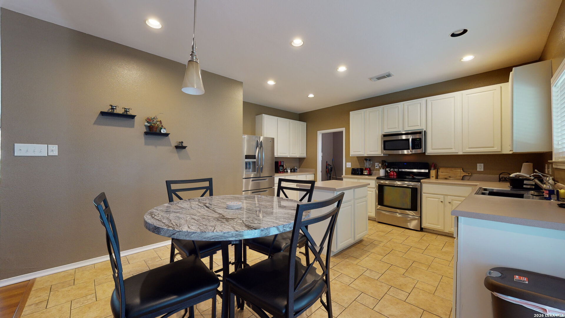 5614 Spring Quail San Antonio, TX 78247 - Photo 12 of 43 a kitchen with a table chairs microwave and cabinets