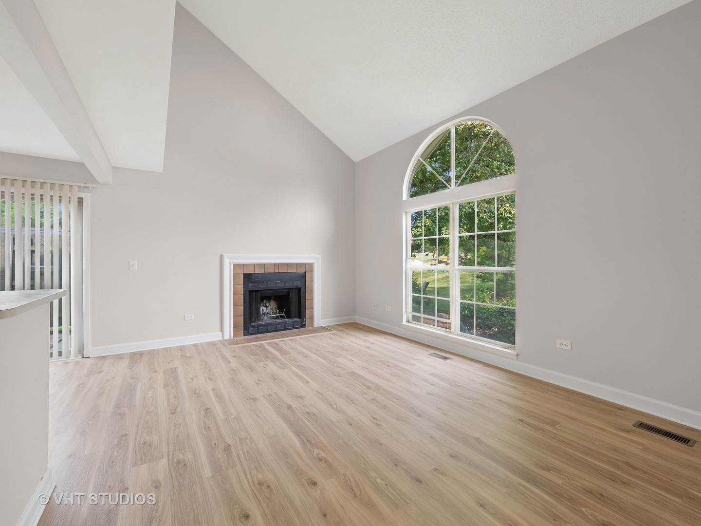 1102 North Knollwood Drive Palatine, IL 60067 - Photo 5 of 15 an empty room with wooden floor a fireplace and windows