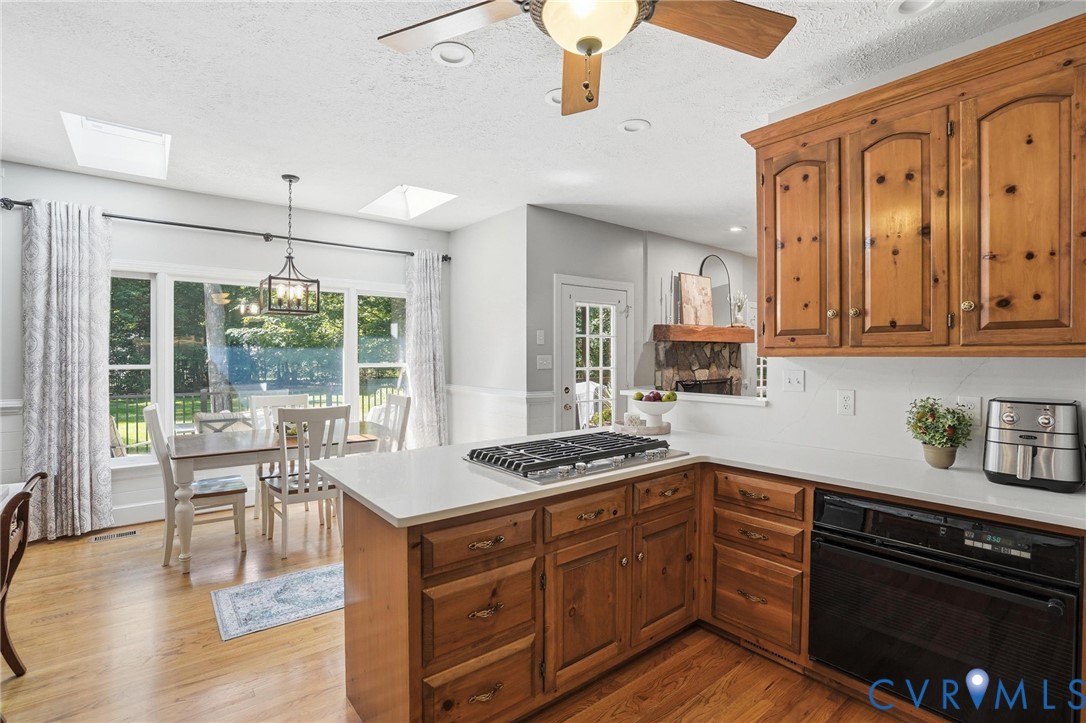 12123 Deer Ridge Court Ashland, VA 23005 - Photo 20 of 63 a kitchen with stainless steel appliances granite countertop a stove a sink dishwasher and cabinets with wooden floor