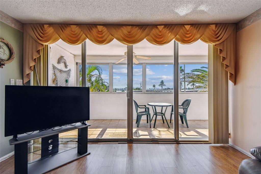 17920 Gulf Boulevard, Unit 208 Redington Shores, FL 33708 - Photo 11 of 98 a living room with large window and a flat screen tv