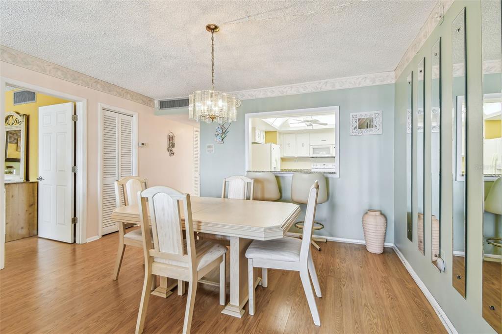 17920 Gulf Boulevard, Unit 208 Redington Shores, FL 33708 - Photo 19 of 98 a view of a dining room with furniture wooden floor and chandelier