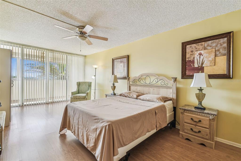 17920 Gulf Boulevard, Unit 208 Redington Shores, FL 33708 - Photo 22 of 98 a bedroom with a bed a dresser and wooden floor