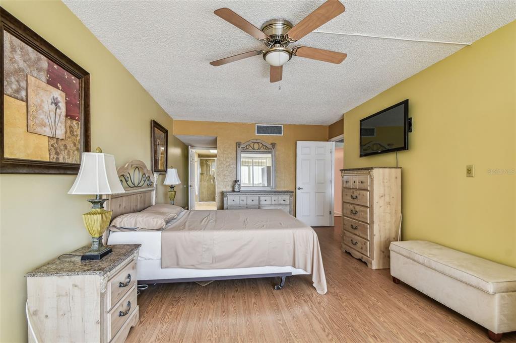 17920 Gulf Boulevard, Unit 208 Redington Shores, FL 33708 - Photo 27 of 98 a bedroom with a bed wooden floor and flat screen tv