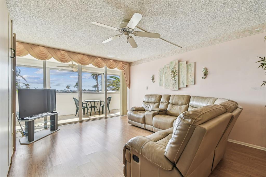 17920 Gulf Boulevard, Unit 208 Redington Shores, FL 33708 - Photo 10 of 98 a living room with furniture a flat screen tv and a floor to ceiling window
