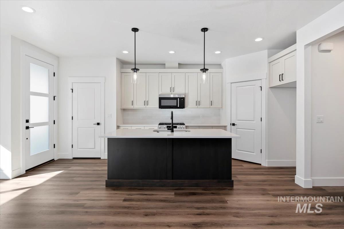 752 South Calhoun Lane Star, ID 83669 - Photo 12 of 45 Kitchen featuring a central island with a light-toned countertop, dark base cabinetry, and a black faucet
