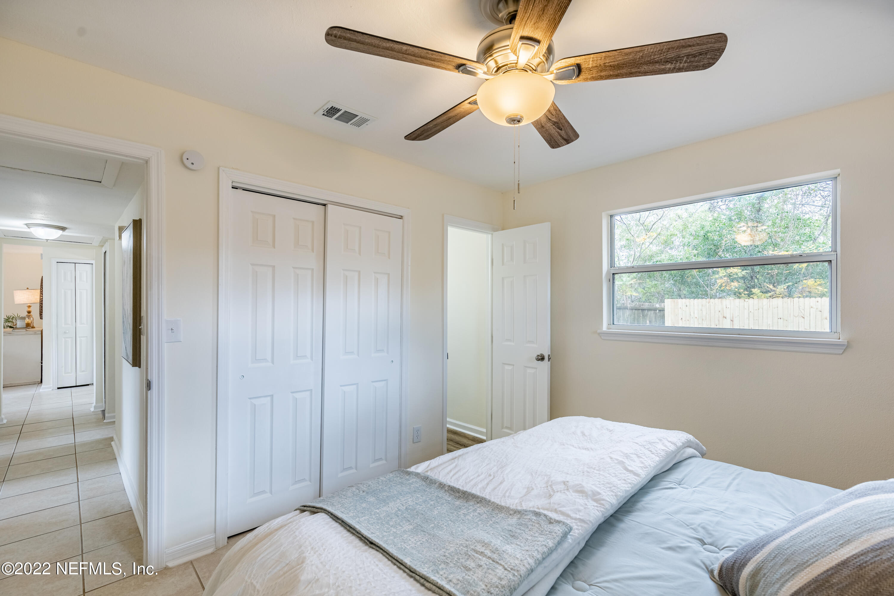 2913 Mansion Road Jacksonville, FL 32277 - Photo 16 of 30 a bedroom with a large bed and a chandelier fan