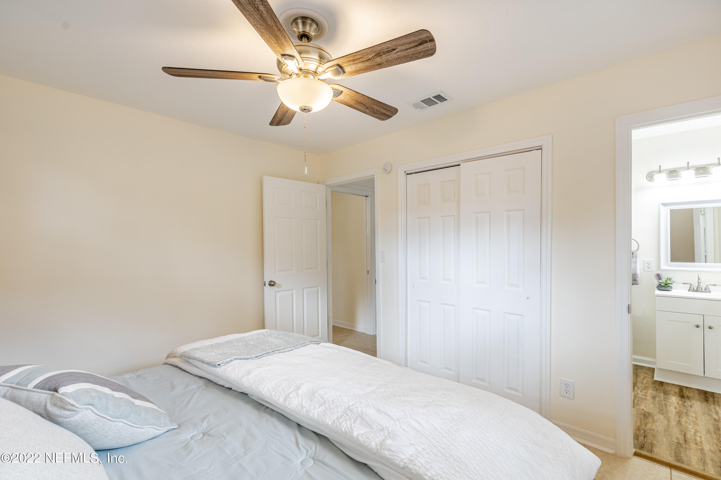 2913 Mansion Road Jacksonville, FL 32277 - Photo 17 of 30 a bedroom with a bed and a chandelier