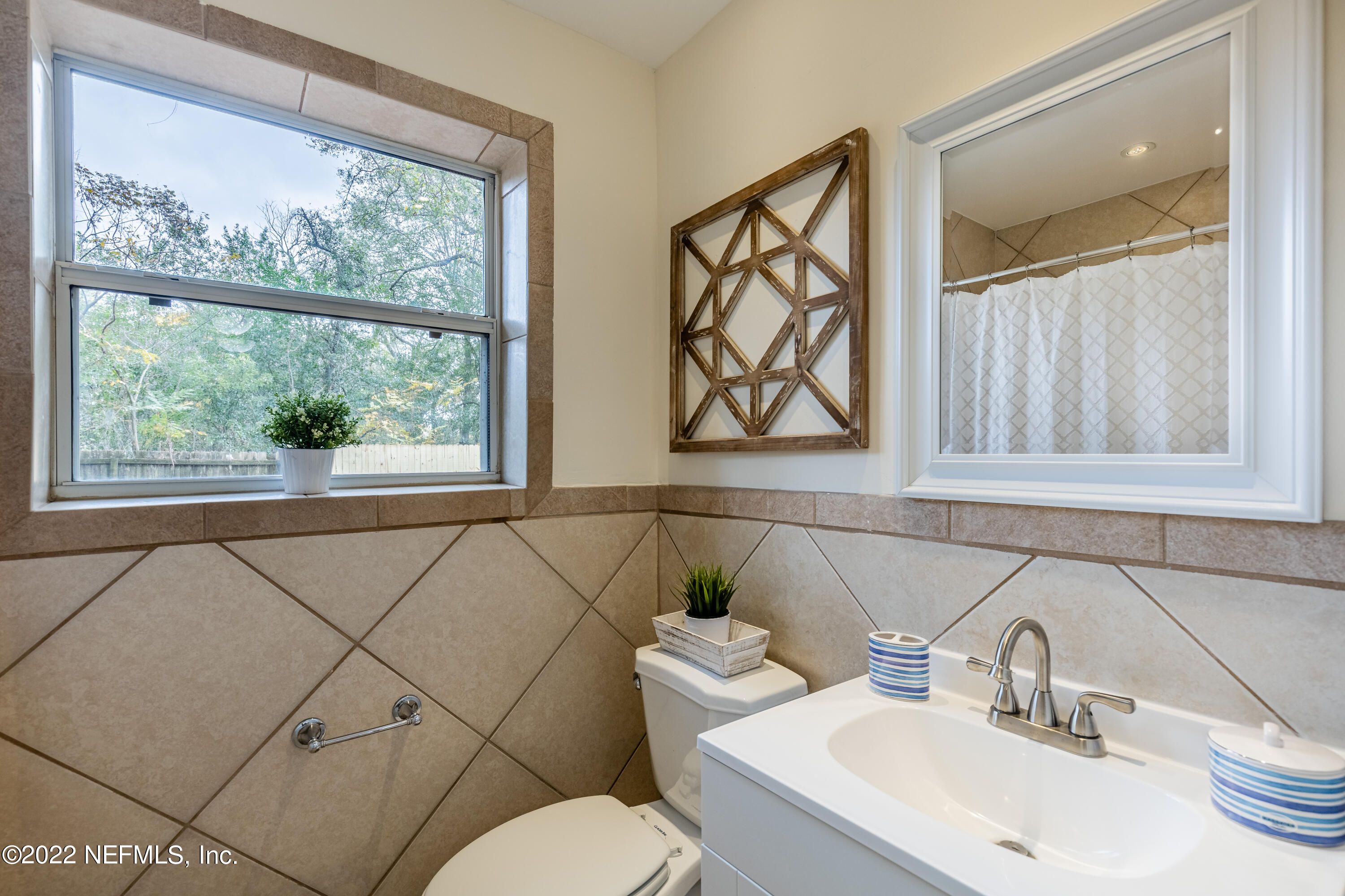 2913 Mansion Road Jacksonville, FL 32277 - Photo 24 of 30 a bathroom with a toilet sink and mirror