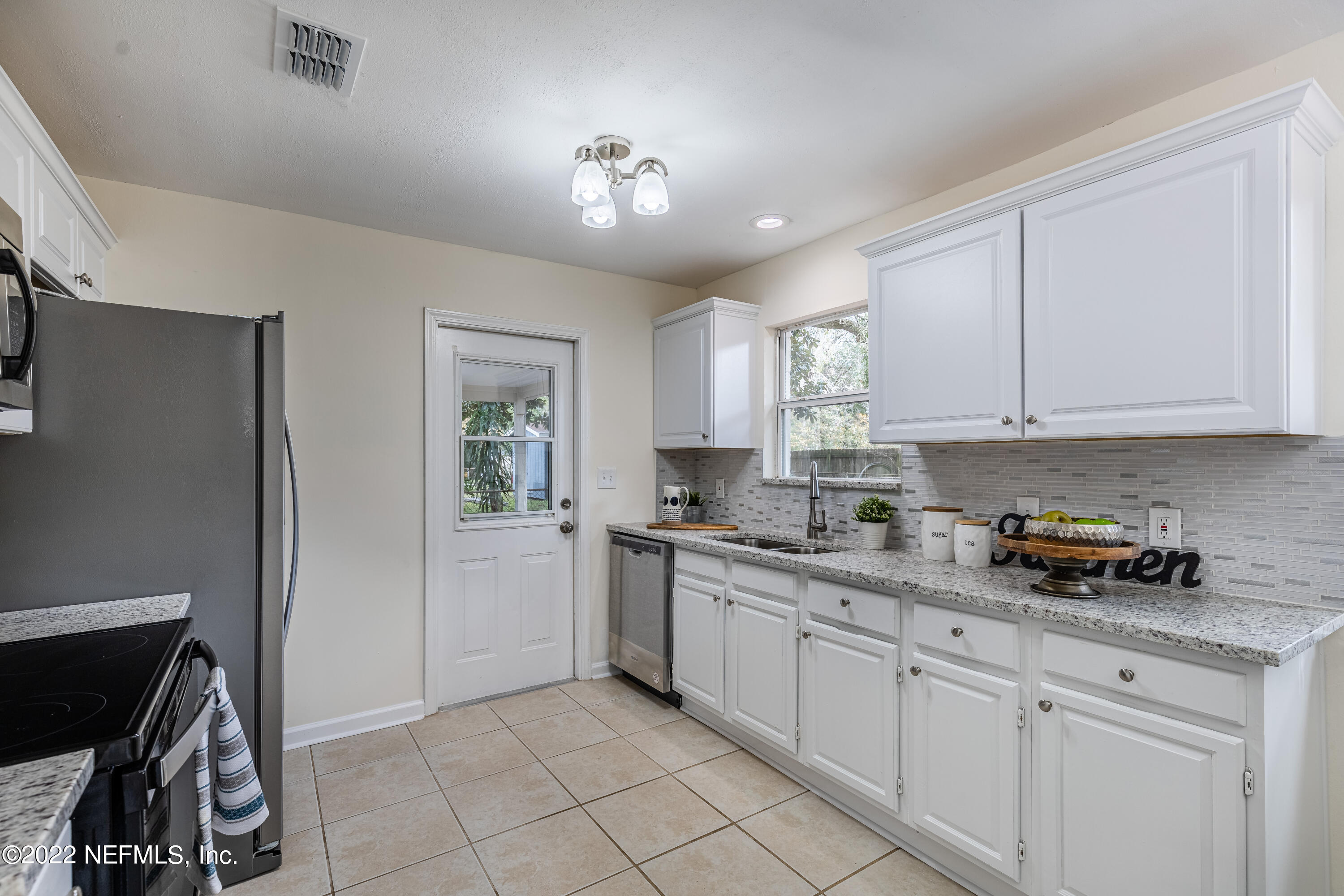 2913 Mansion Road Jacksonville, FL 32277 - Photo 10 of 30 a kitchen with a white cabinets and window