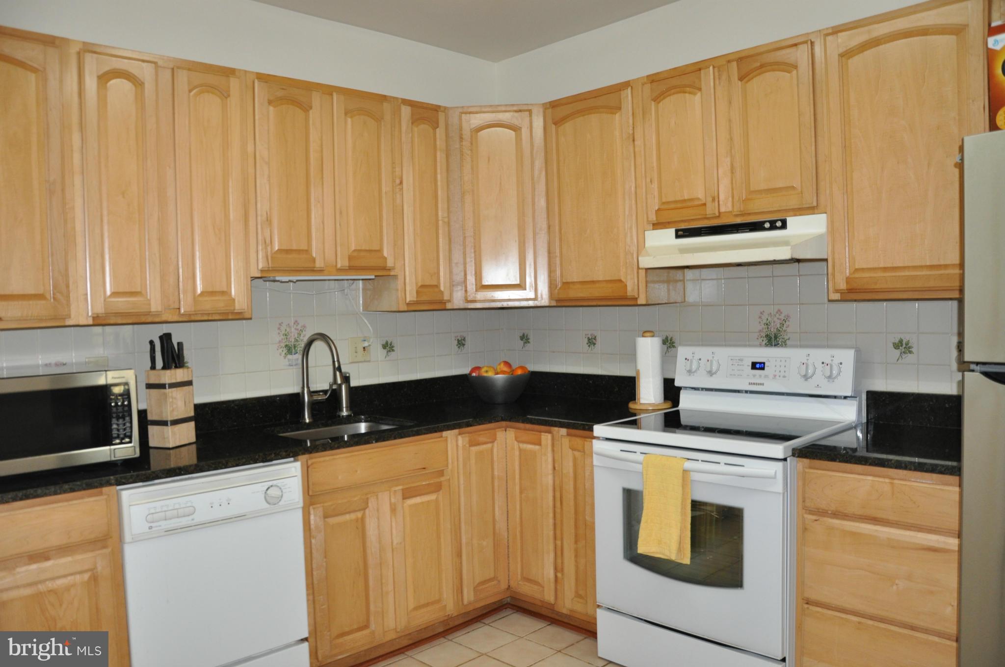 7938 Spring Forest Court, Unit 7938 Springfield, VA 22152 - Photo 12 of 29 a kitchen with stainless steel appliances a stove a sink a refrigerator and cabinets