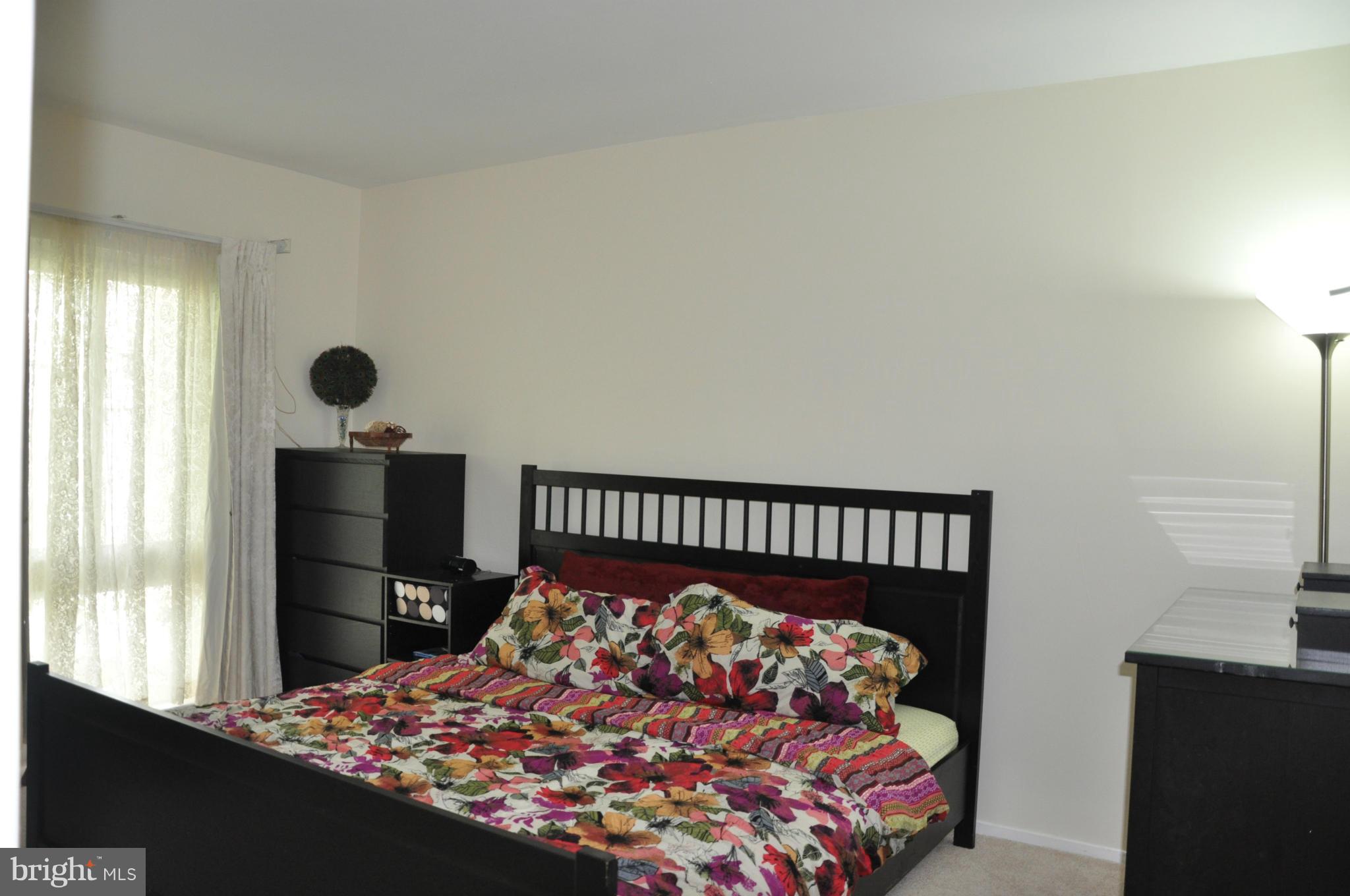 7938 Spring Forest Court, Unit 7938 Springfield, VA 22152 - Photo 16 of 29 a bed sitting in a bedroom next to a window